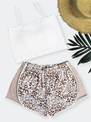 a pair of leopard print shorts next to a straw hat