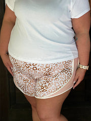 a woman in white shirt and leopard print shorts
