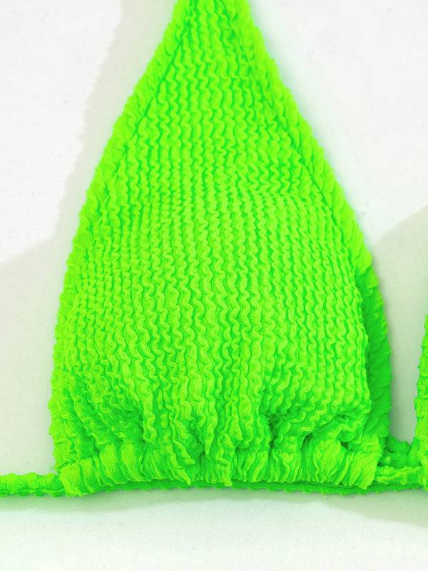 a close up of a green towel on a white surface