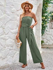 a woman wearing a strapless jumpsuit and a hat