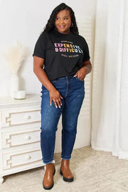 a woman in a black shirt and jeans standing in front of a white dresser