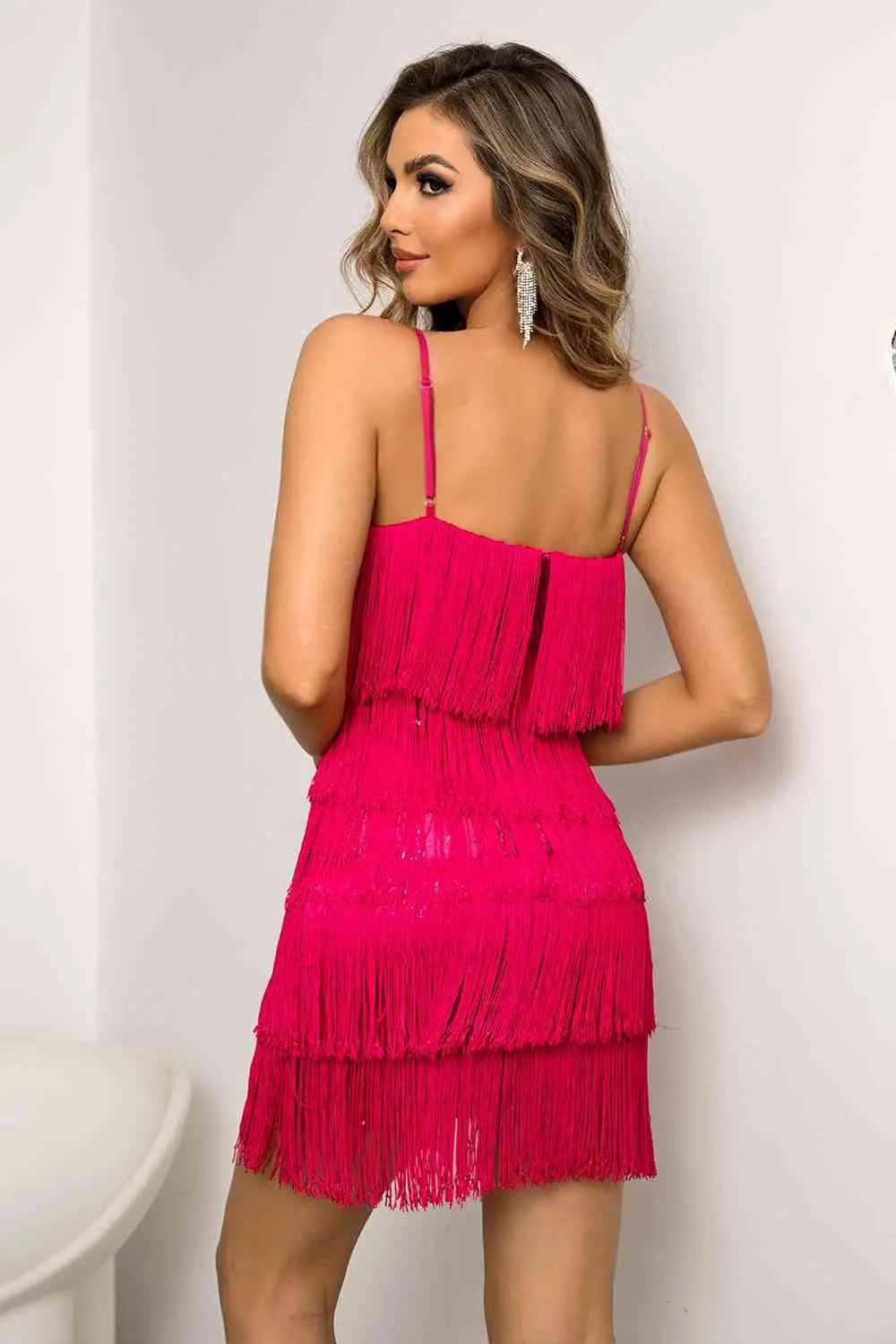 a woman wearing a pink fringe dress