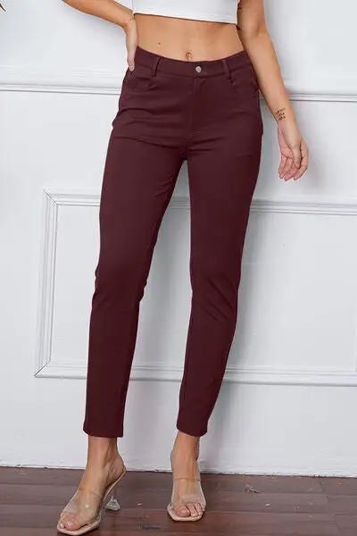 a woman in a white top and maroon pants