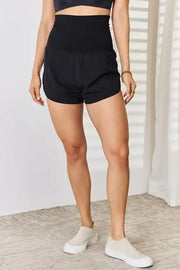 a woman wearing a black top and shorts
