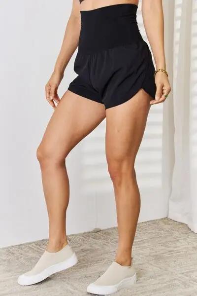 a woman in a black top and shorts
