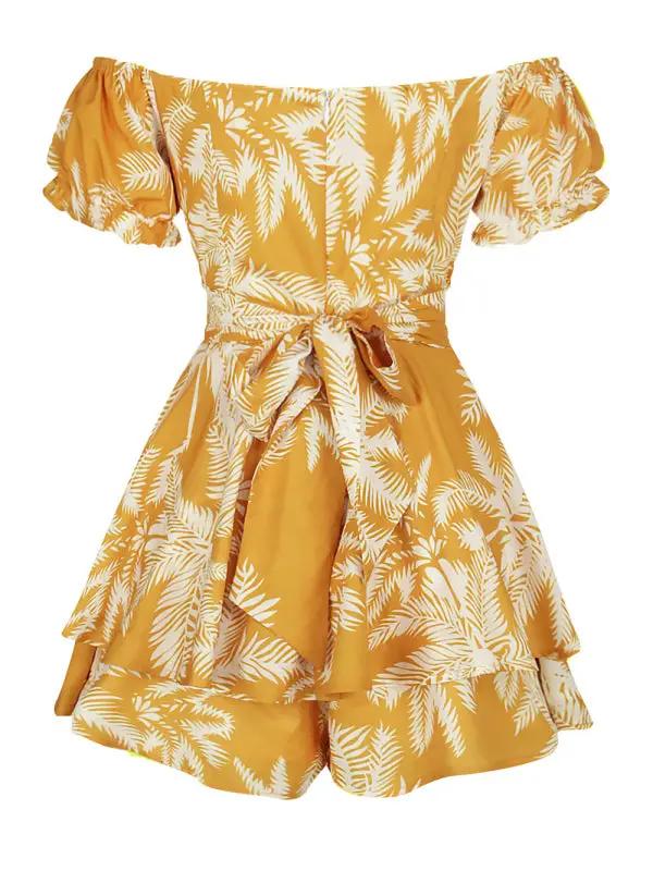 a yellow dress with white leaves on it