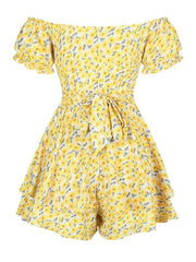 a yellow floral romper with a bow at the waist
