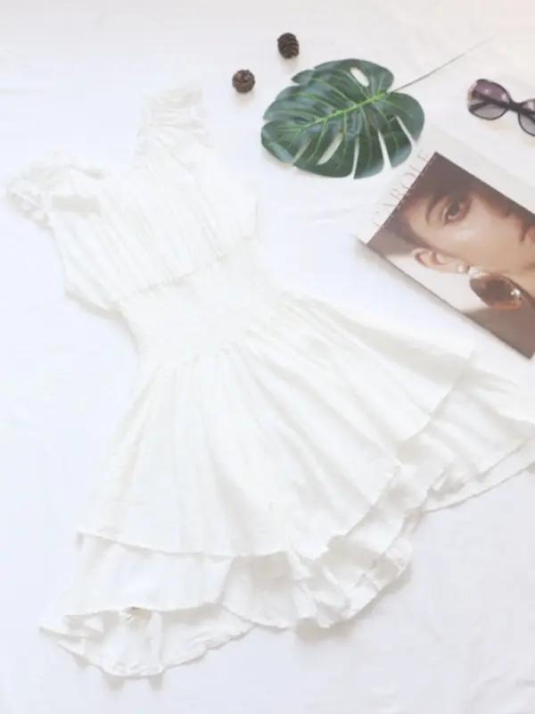 a white dress and sunglasses on a white surface