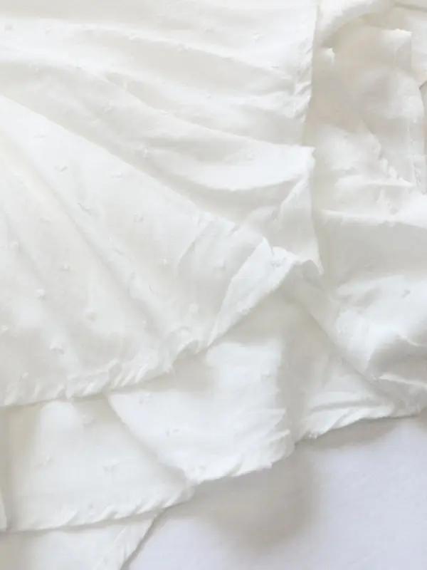 a close up of a white sheet on a bed