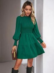 a woman wearing a green dress and boots