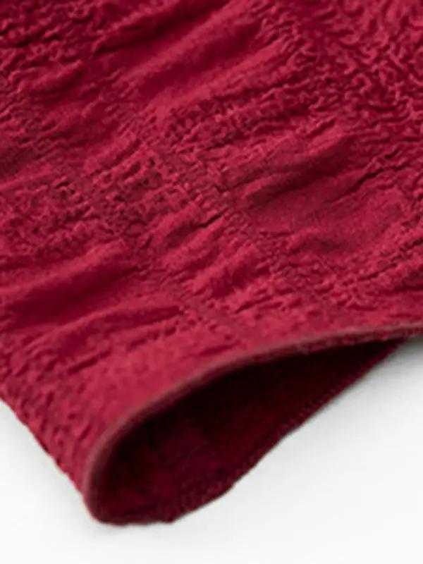a close up of a red blanket on a white surface
