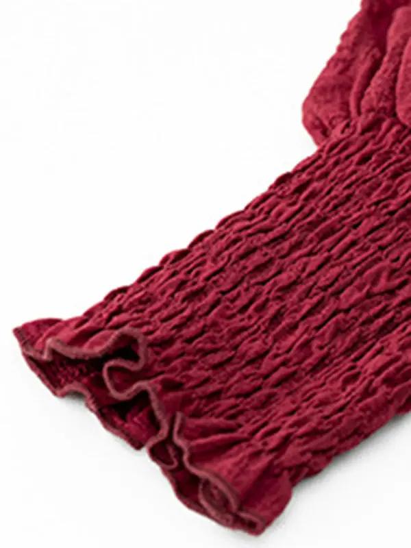 a red scarf laying on top of a white surface