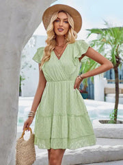 a woman wearing a green dress and hat