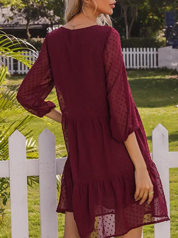 a woman standing on a white fence wearing a maroon dress